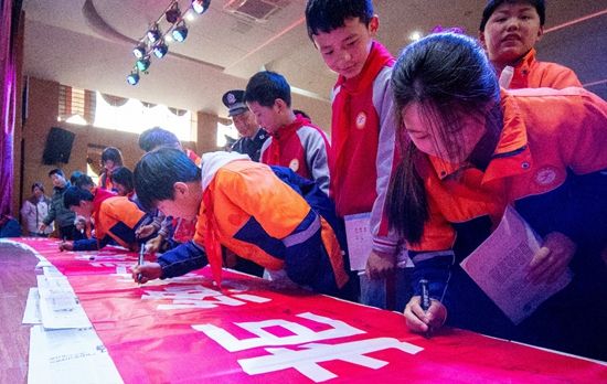 　　3月27日，江西抚州，金溪县锦绣小学的学生在法治安全教育课后，在“拒绝校园欺凌，共建平安校园”宣传长幅上签名。视觉中国供图