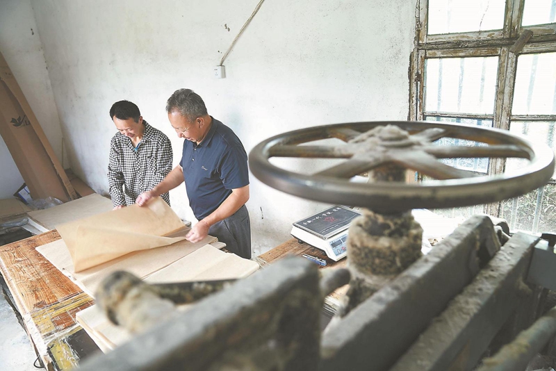 刘同烟（右）和省非遗传承人刘绍成在精挑桑皮纸。.jpg